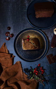 Schokokuchen mit Pumpkin Spice Glasur auf herbstlich dekoriertem Tisch