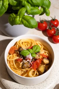 Vegetarische Spaghetti garniert mit Auberginen, Tomaten und Basilikum